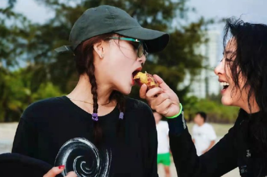 殷桃穿吊带背心现身海滩，戴大金链子秀锁骨，张嘴被人喂食太性感